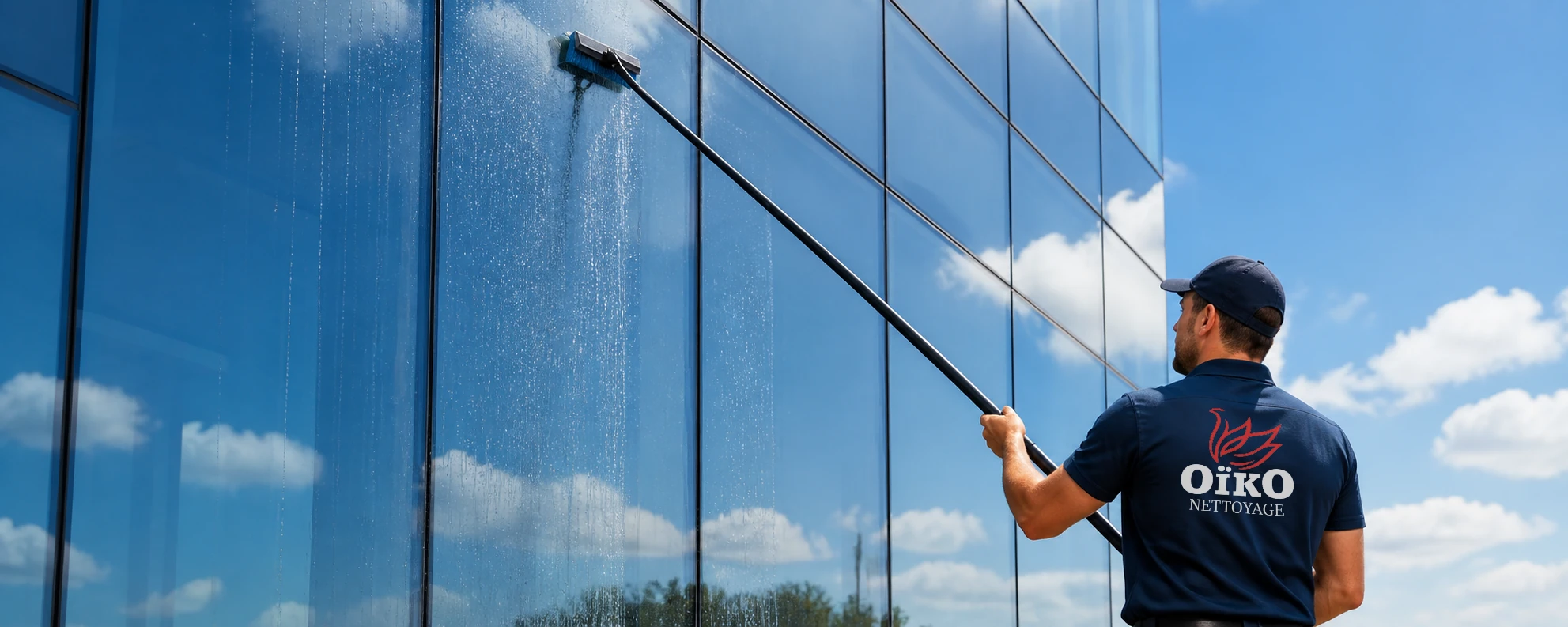 Illustration d’un laveur de vitres Oïko utilisant une perche à eau pure sur une façade vitrée
