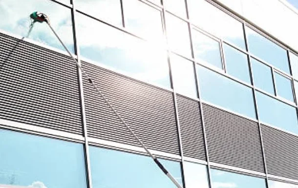 Nettoyage de vitres en hauteur avec une perche télescopique